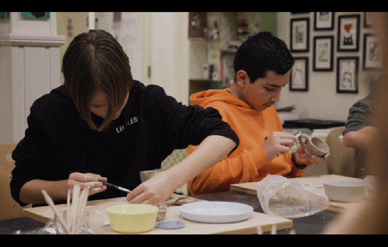 Två tonårspojkar arbetar med keramik. 