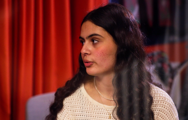 En kvinna som står framför ett draperi.