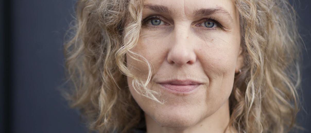 Bild på Marit Kapla, mörkgrå bakgrund.