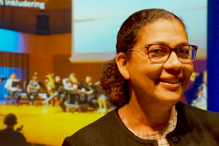 Bild på Sophia Alexandersson, med en orkester i bakgrunden. 