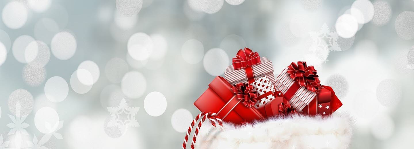 En röd säck med inslagna paket. Snöflingor i bakgrunden.