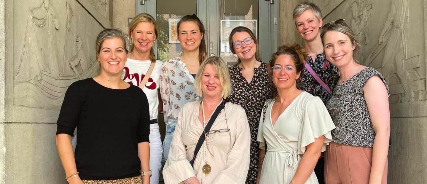 Group photo of eight women standing outside. 