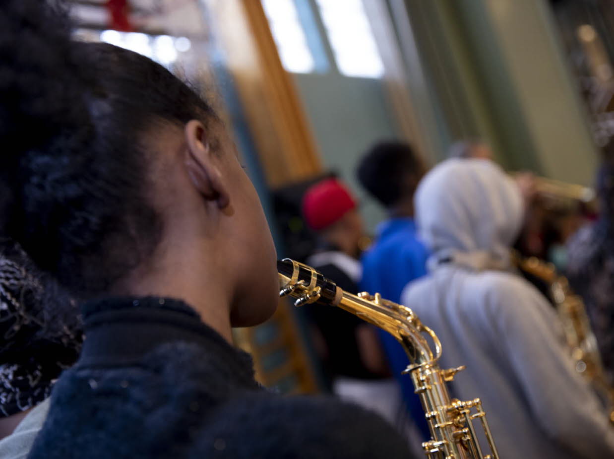 Barn som spelar blåsinstrument. 