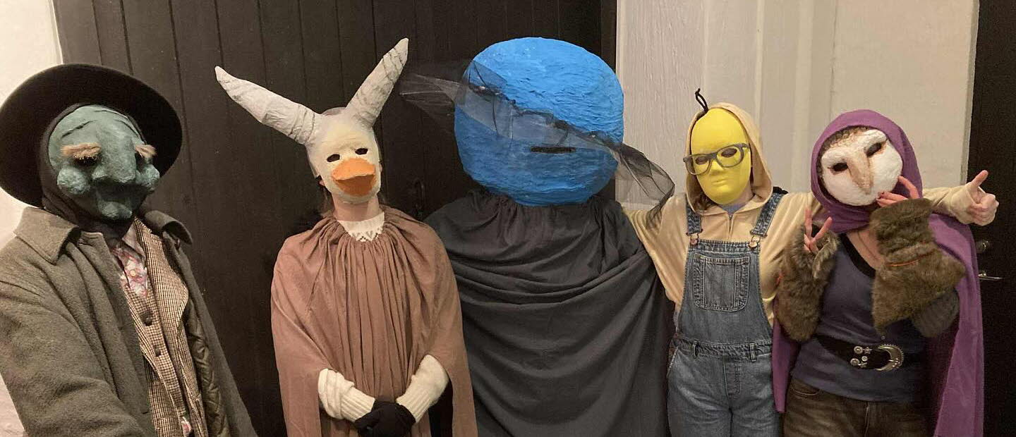 Fem undomar i masker och kostymer.