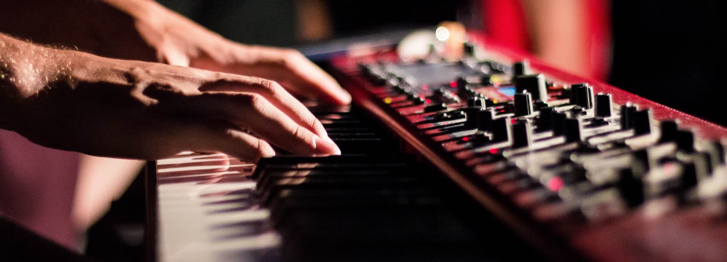 Närbild på händer som spelar keyboard i en studio.