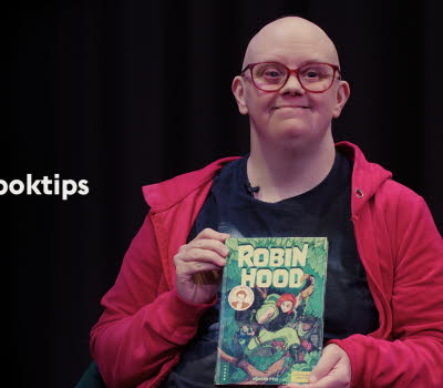 En kvinna håller upp sitt Disney-boktips.