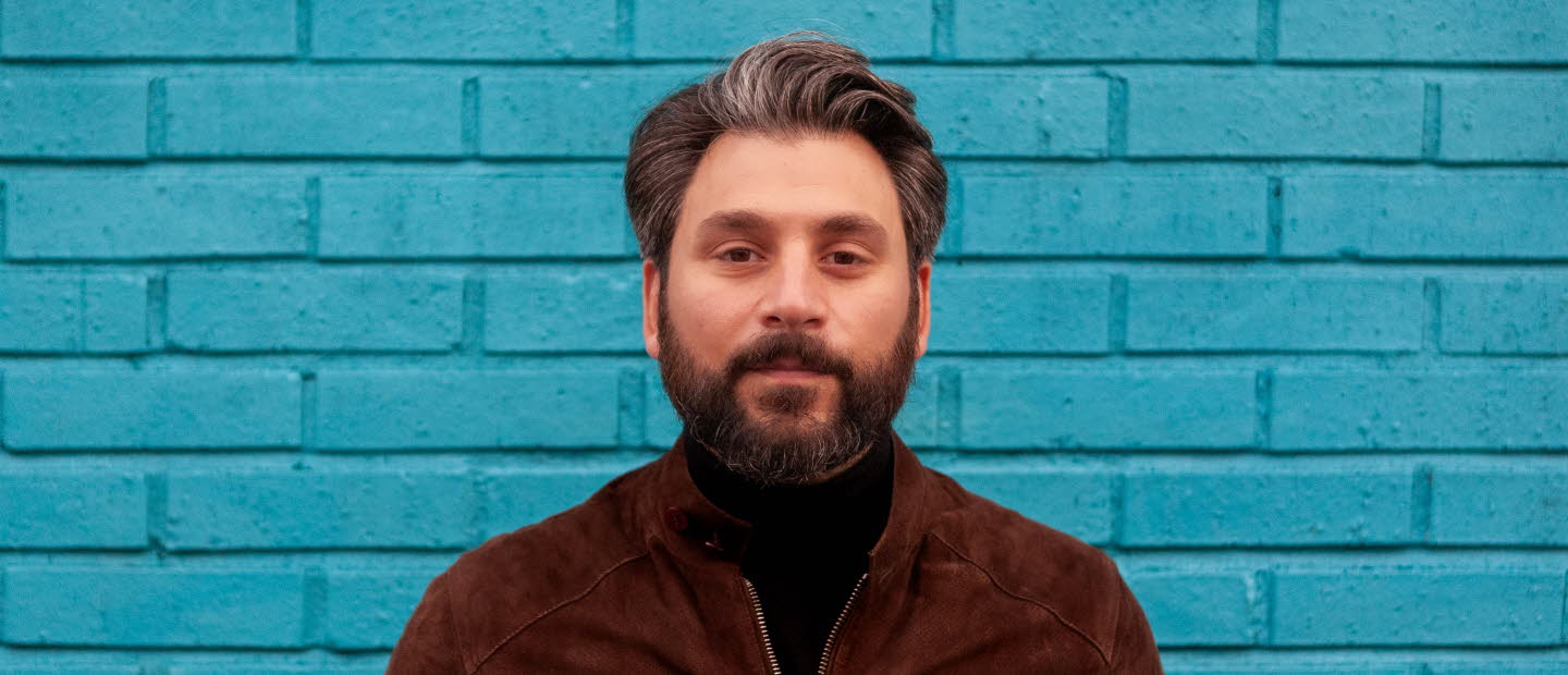 Fotografi av Daniel Boyacioglu mot en blå bakgrund