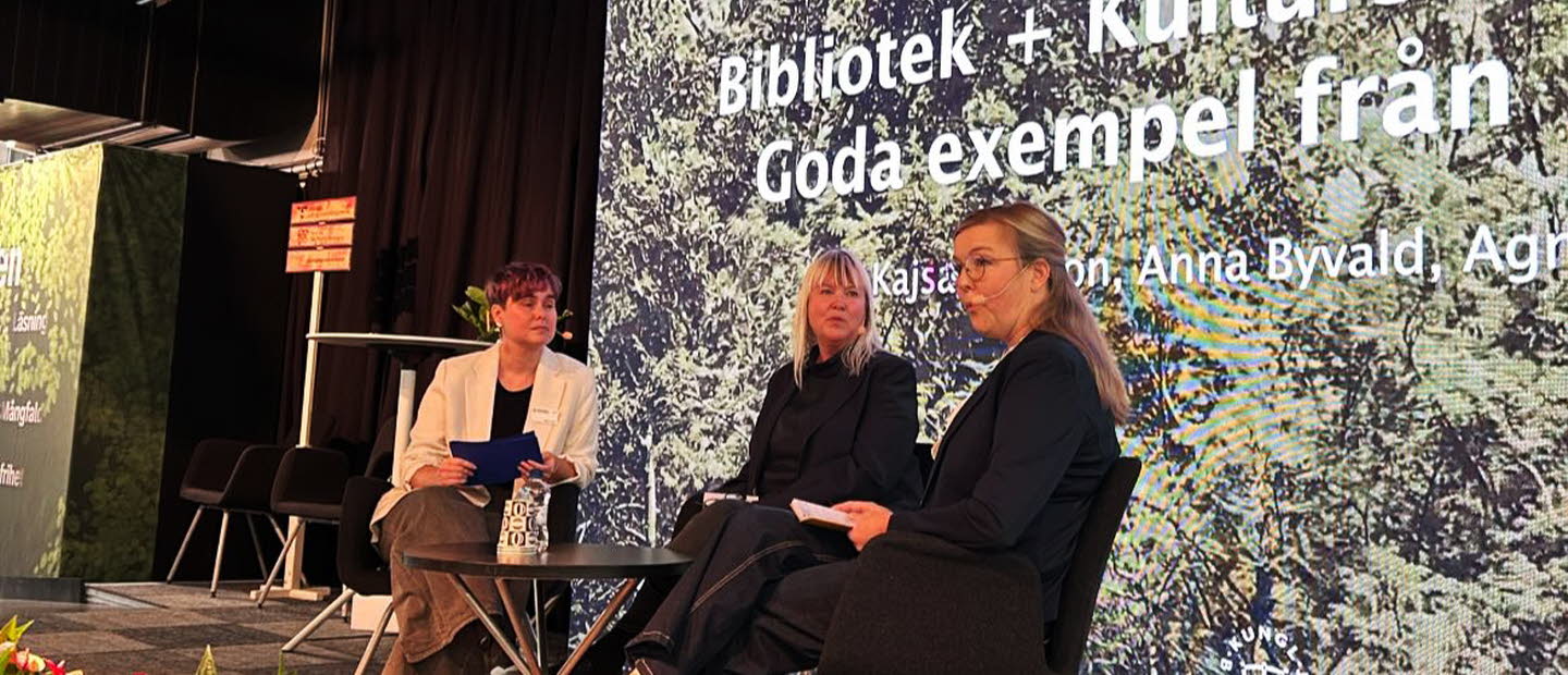 Tre personer sitter på en scen och samtalar.