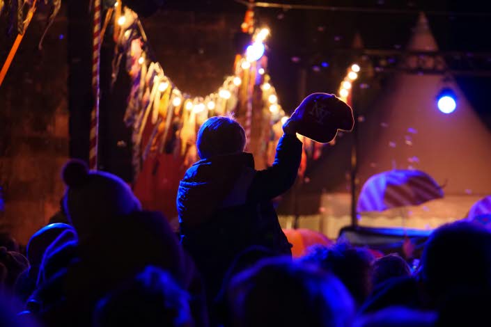 Publik framför en scen i dunkel lila beslysning.