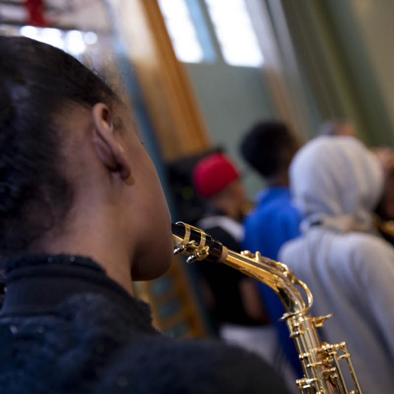 Barn som spelar blåsinstrument. 