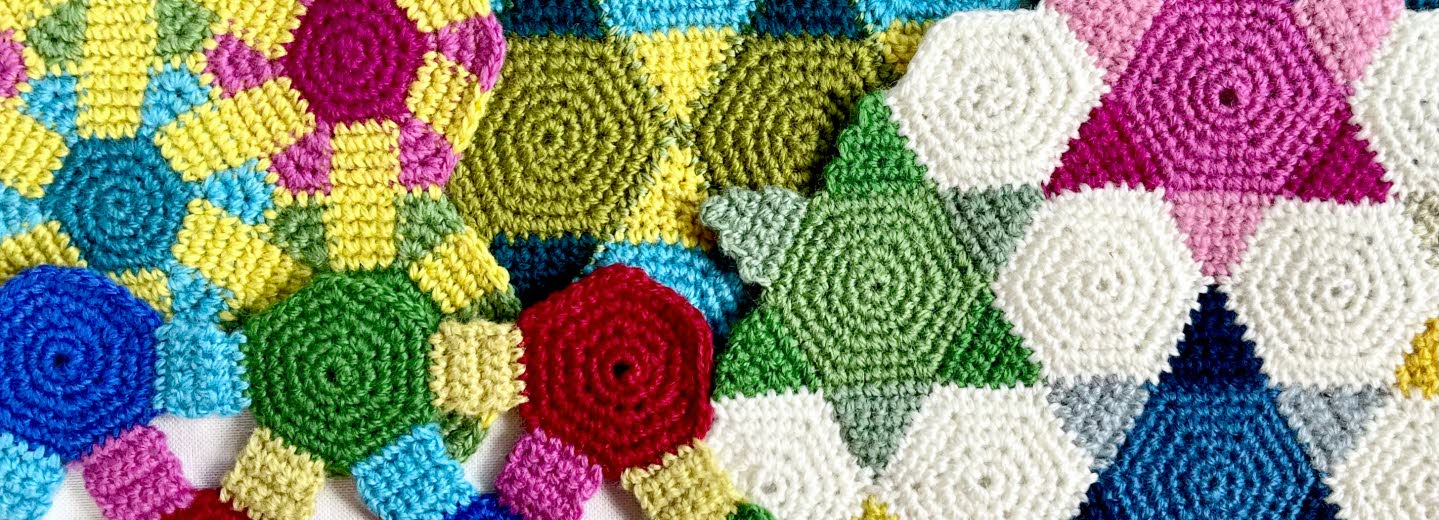 Färgglad virkad textil med geometriska mönster i olika former och färger.