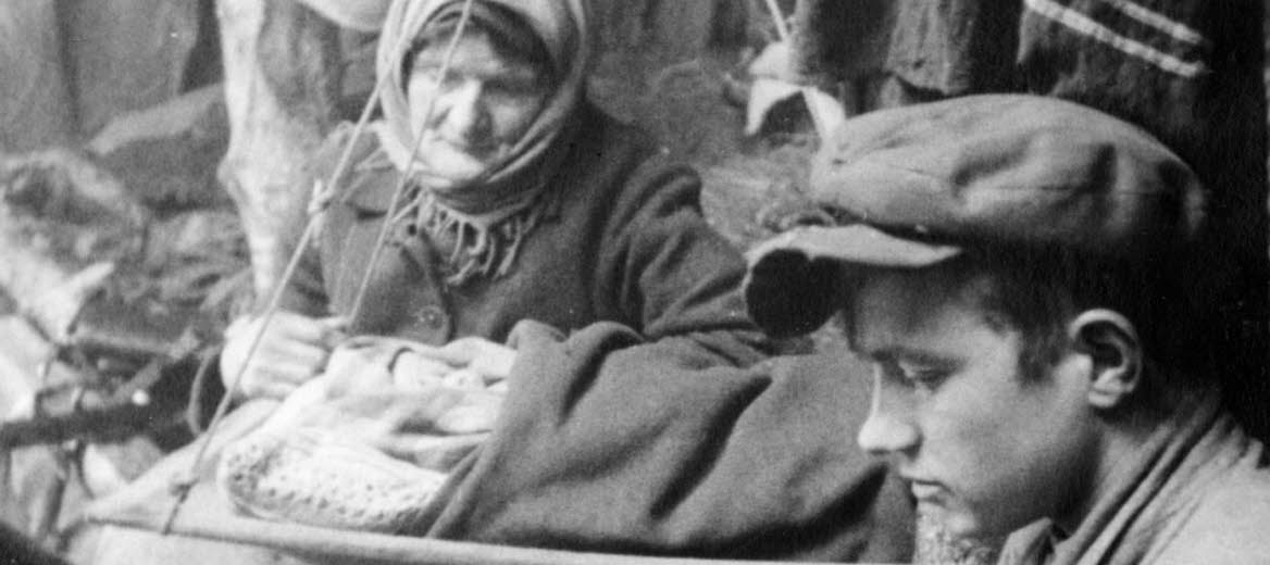 Book cover of "onda nätters drömmar", an old photo of a young man loading a gun, and old woman is looking at him.