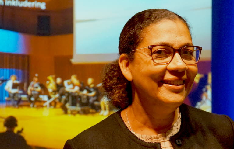 Bild på Sophia Alexandersson, med en orkester i bakgrunden. 