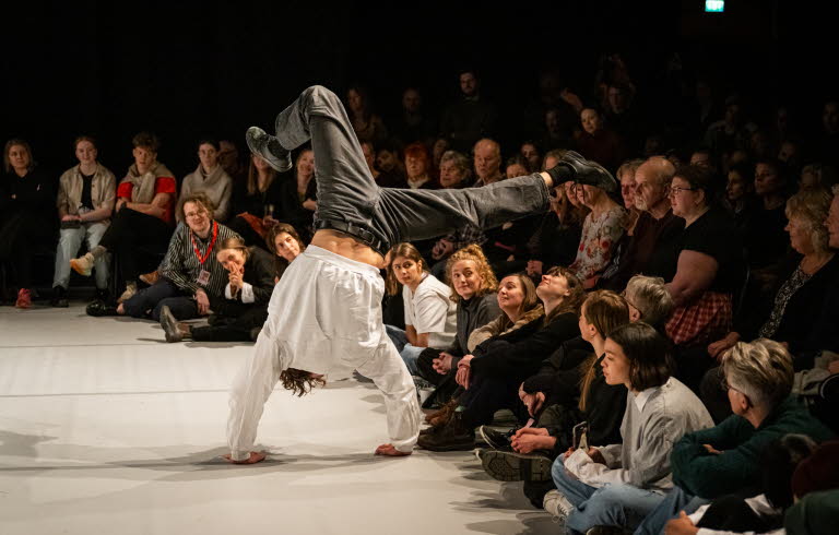 Kille står på händer inför en publik.