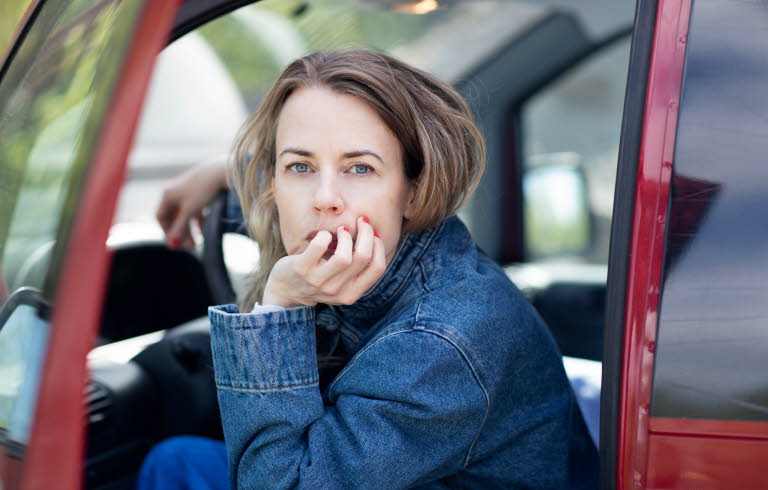 Portrait of Annika Norling sitting in a red car.
