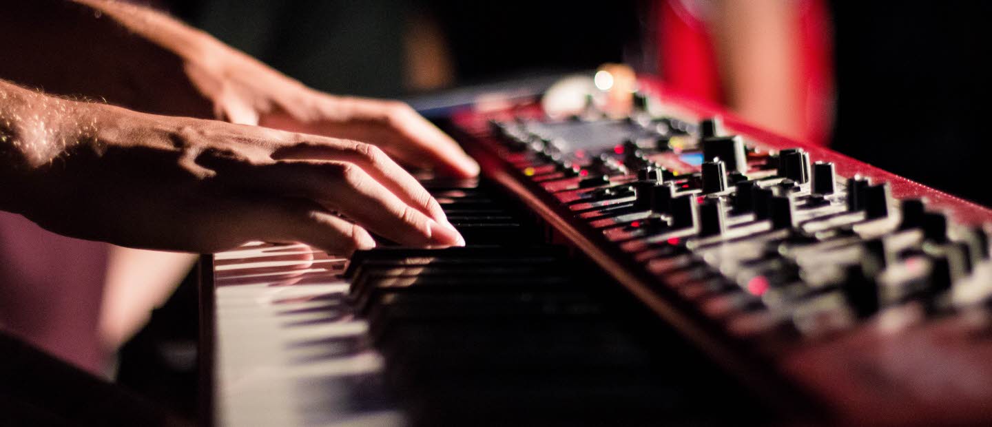 Närbild på händer som spelar keyboard i en studio.