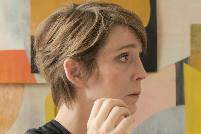 Kvinna framför ett konstverk.