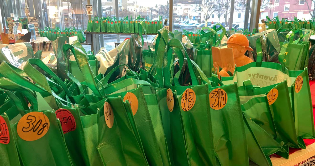 Rader med gröna, numrerade påsar, fyllda med böcker.