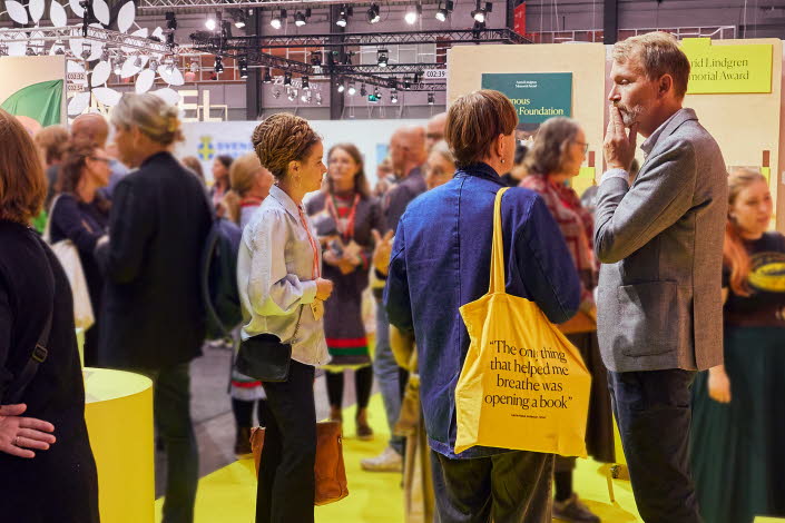 Människor står och samtalar i en monter på Bokmässan.
