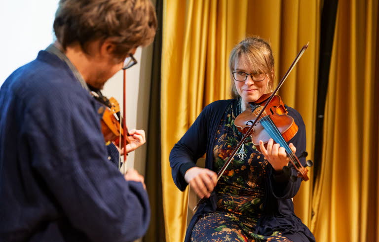 Two people playing the violin.