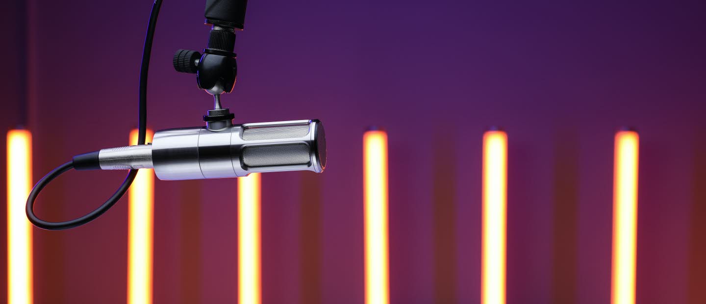 Foto på mikrofon. Smala ljuspelare i bakgrunden.