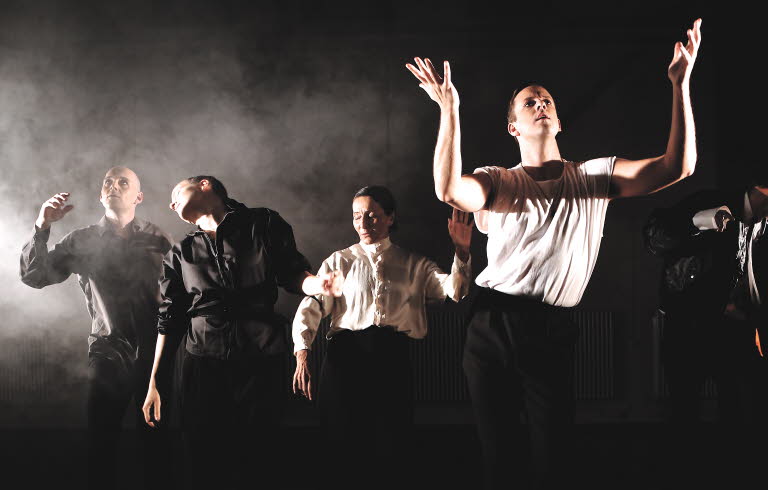 Föreställningsbild Rivers of Färila. Manliga skådepselare i dans, svart bakgrund och rök. 