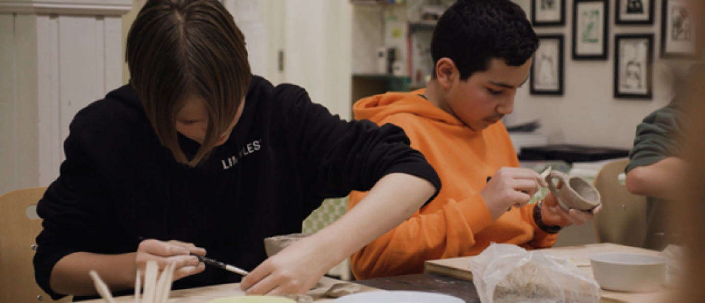 Två tonårspojkar arbetar med keramik. 