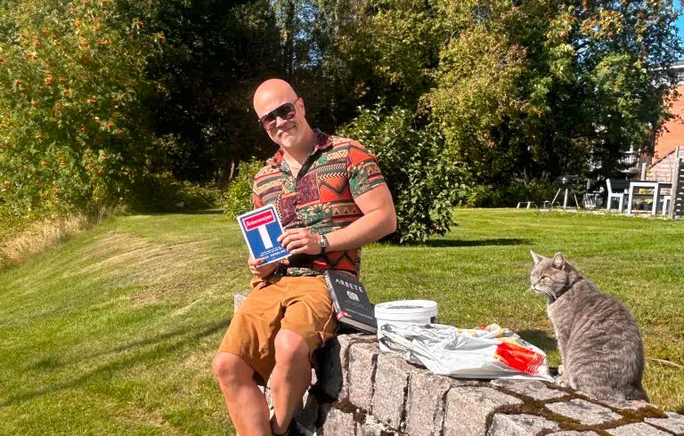 Tommy Bildström sitter på en mur.