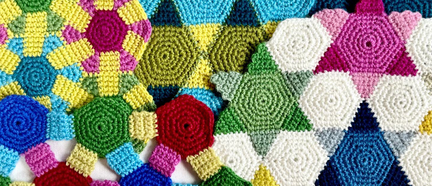 Färgglad virkad textil med geometriska mönster i olika former och färger.