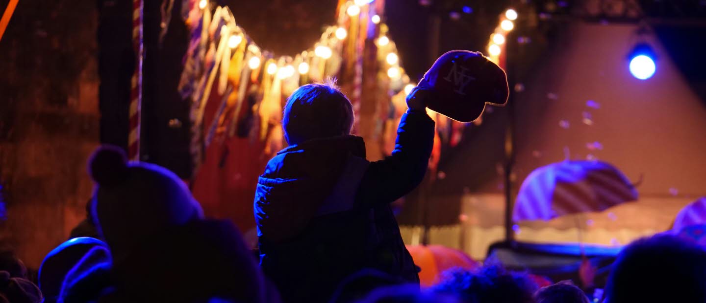 Publik framför en scen i dunkel lila beslysning.