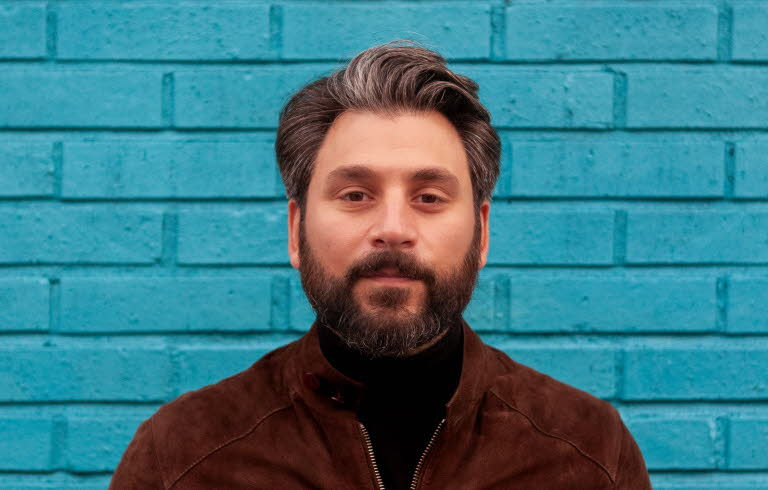 Fotografi av Daniel Boyacioglu mot en blå bakgrund