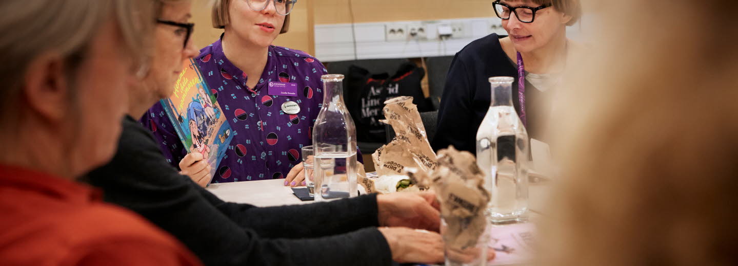 A group of women sitting at a table and talking.