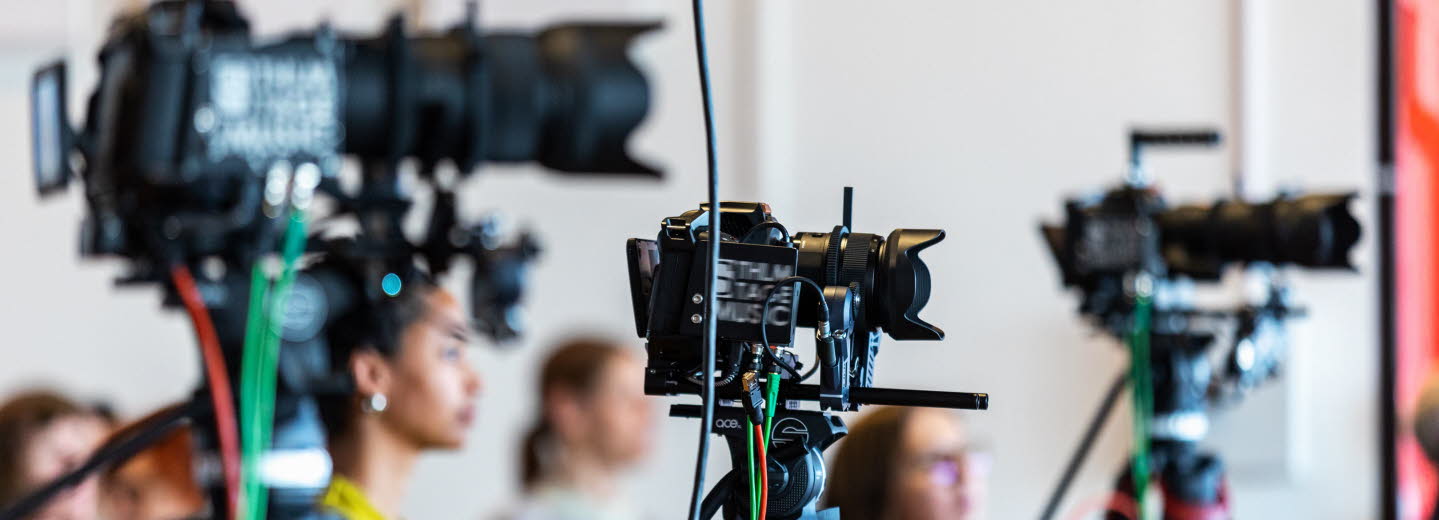 Tre filmkameror på stativ.