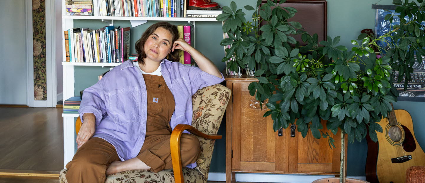 Läsambassadören Agnes Török i en fåtölj framför en bokhylla.