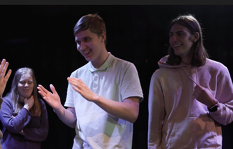 Fyra personer agerar på en scen. 