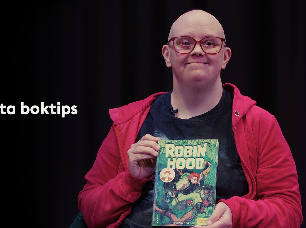 En kvinna håller upp sitt Disney-boktips.