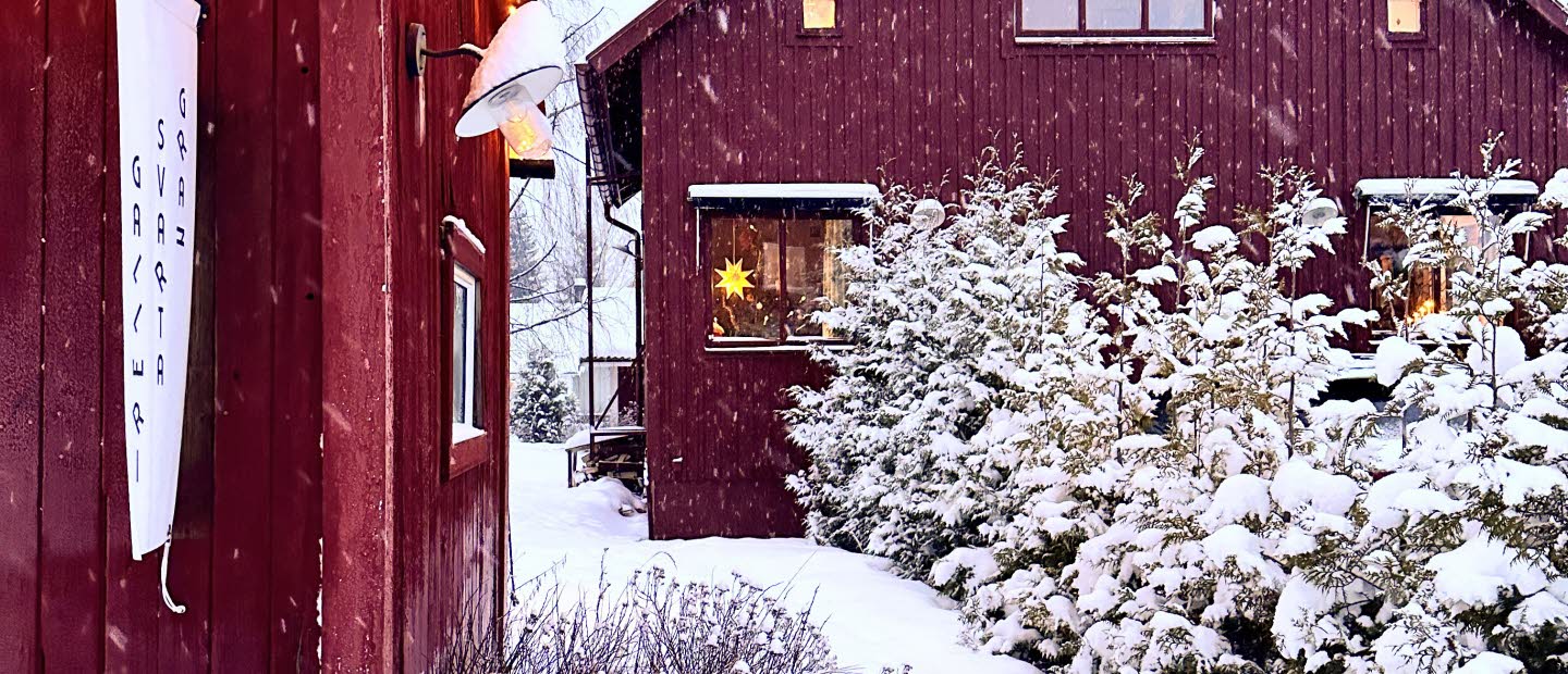 Två röda hus i vinterlandskap.