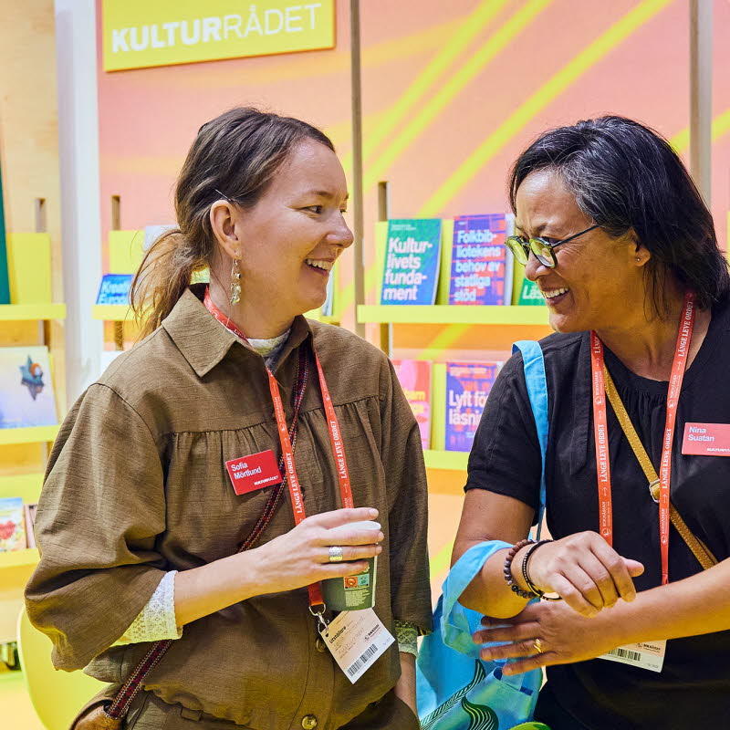 Två personer står i Kulturrådets monter på Bokmässan.