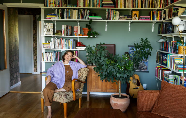 Läsambassadören Agnes Török i en fåtölj framför en bokhylla.