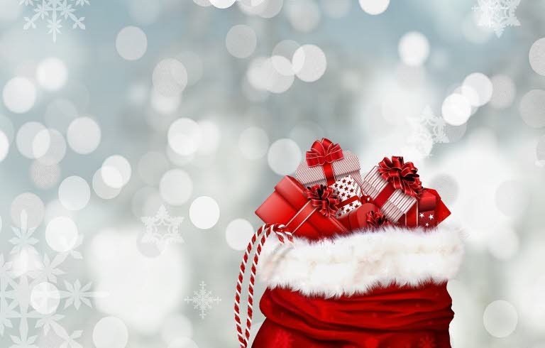 En röd säck med inslagna paket. Snöflingor i bakgrunden.