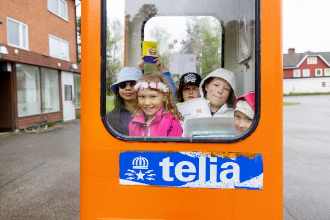 Många barn inträngda i en gammal telefonkiosk.