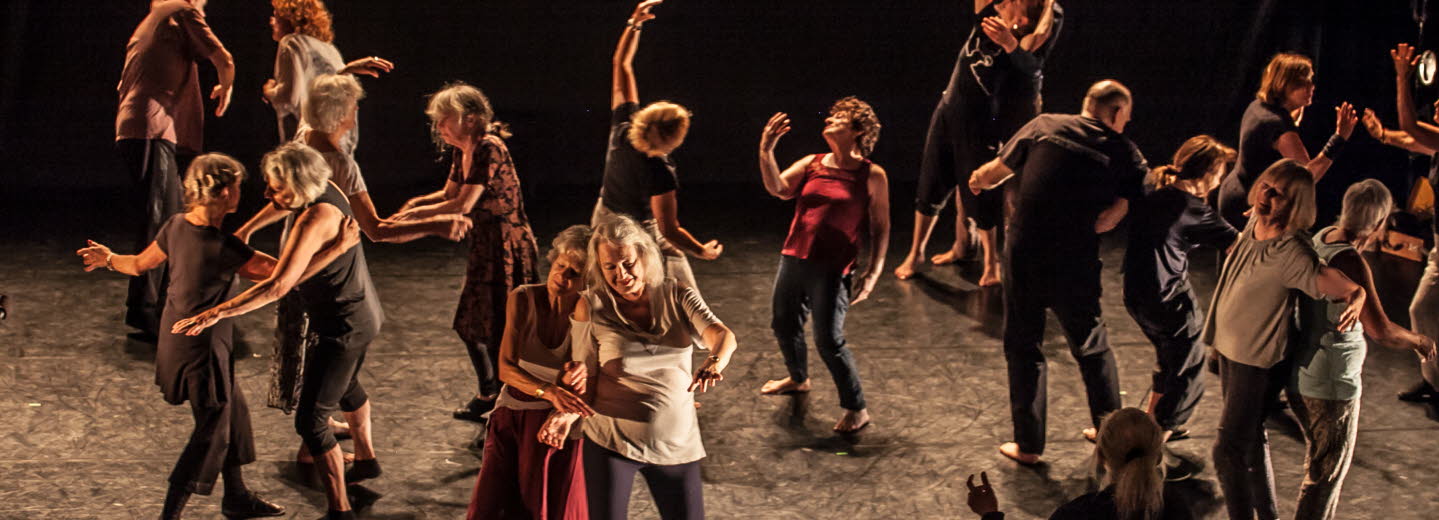 Äldre människor dansar tillsammans på en scen.