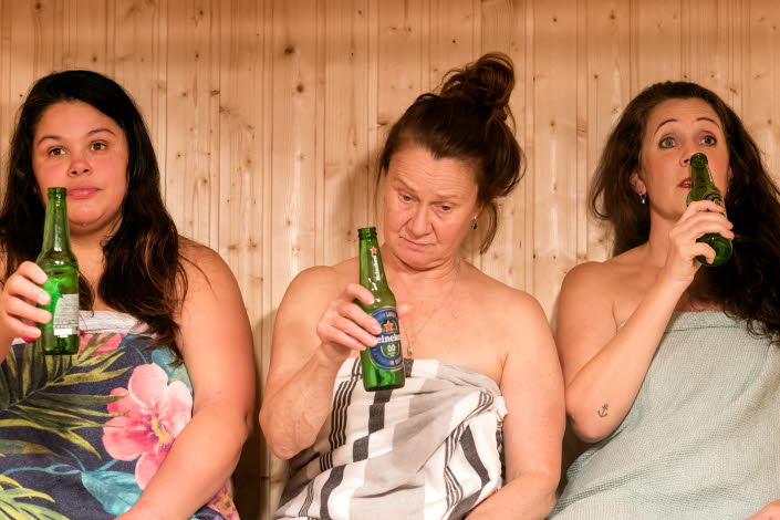 Tre kvinnor i bastun som skålar i öl. Foto: Elin Berge.
