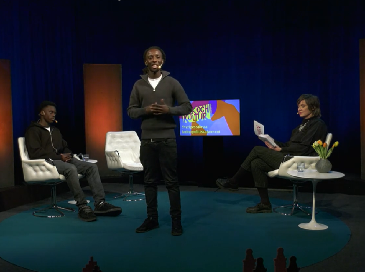 En kille står i en studio och läser poesi.