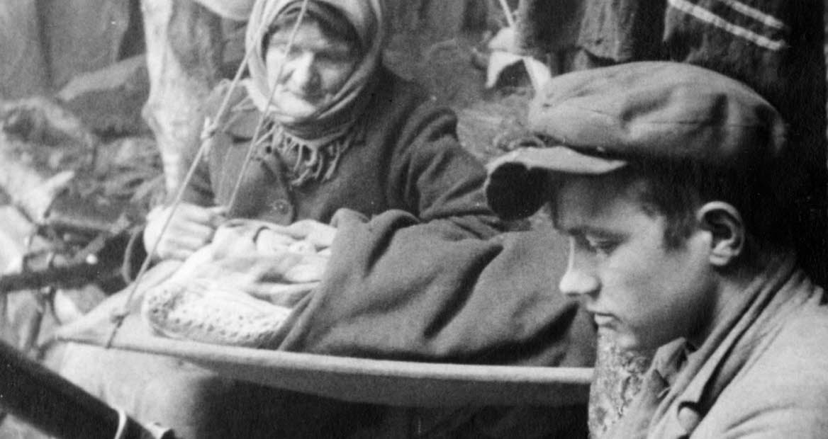 Book cover of "onda nätters drömmar", an old photo of a young man loading a gun, and old woman is looking at him.