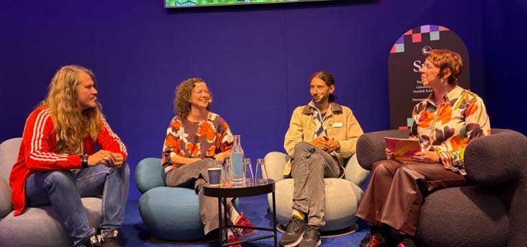 Paneldeltagare på scenen.