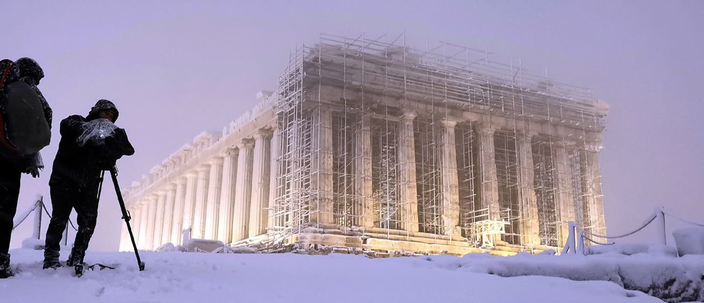 Två fotografer dokumenterar stor byggnad i snöstorm.Bild: Stavros Petropoulos /Alaska for Onassis Foundation.