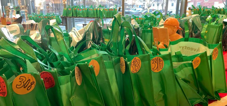 Rader med gröna, numrerade påsar, fyllda med böcker.