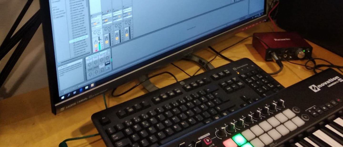 MIDI-tangentbord och datorskärm med musikprogramvara.
